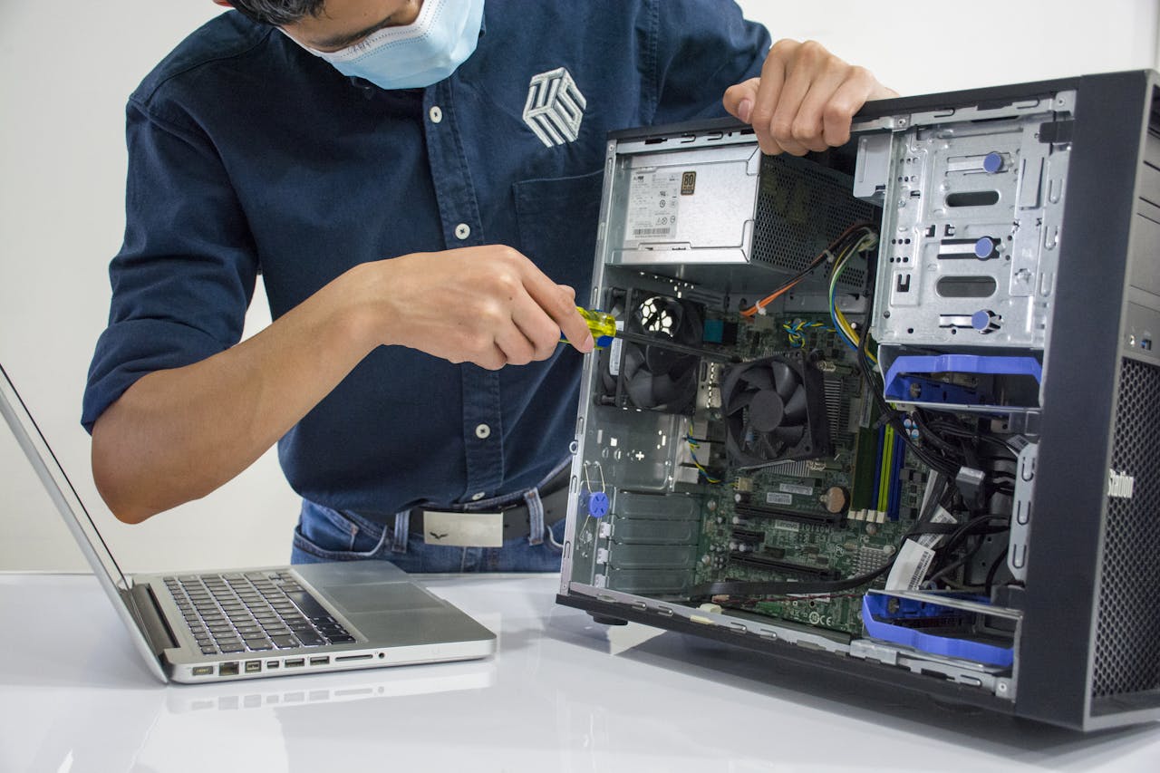 Services A technician repairs a desktop computer in an indoor setting, illustrating tech maintenance.